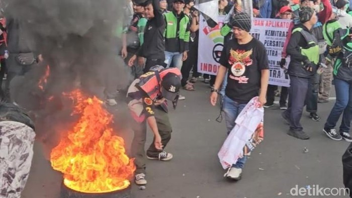 Demo Ojol di Patung Kuda: Massa Bakar Ban, Desak Pertemuan Menhub!